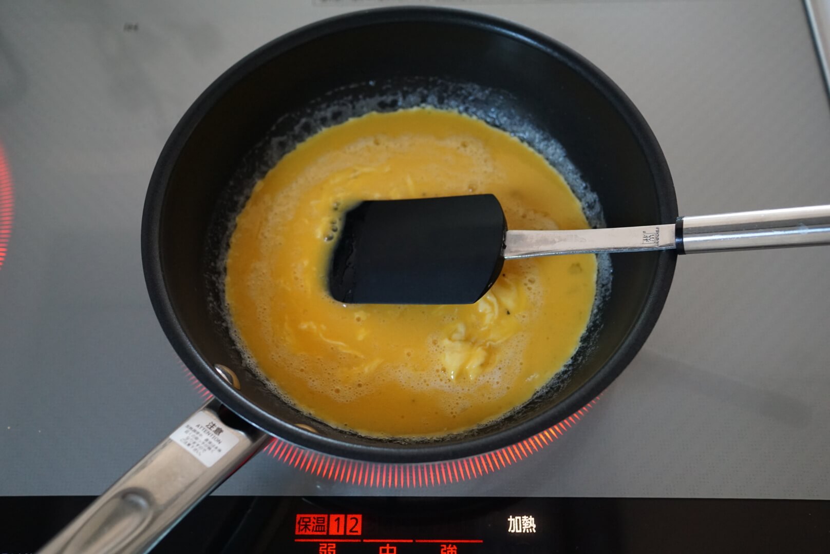 溶いた卵を入れ、フライパンをゆすりながらゴムベラで混ぜます。