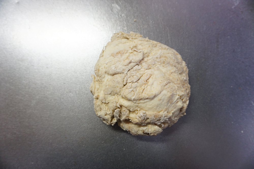 ひとまとまりになったところでボウルから出し、こね台で1分叩きつけます。