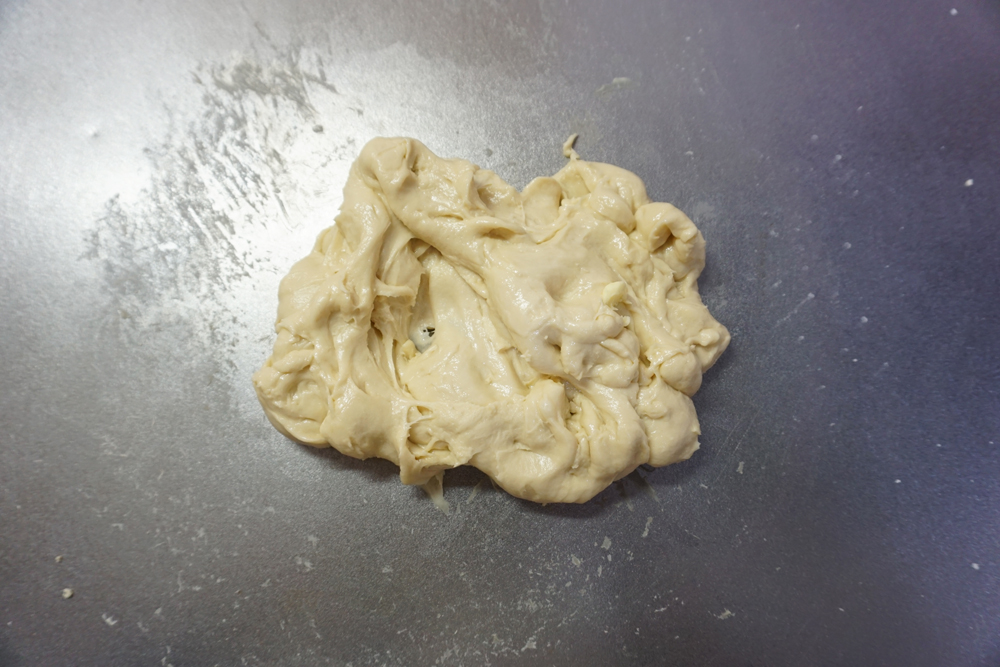 バターを加えてさらに捏ねます。 せっかくまとまった生地がバラバラになりますが、表面のテカリが消え、しっとりするまで約5分程度捏ねます。