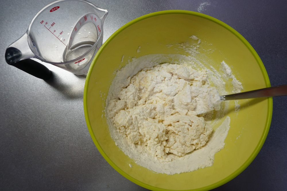 ドライイーストめがけて水を9割入れ、スプーンや菜箸で混ぜます。