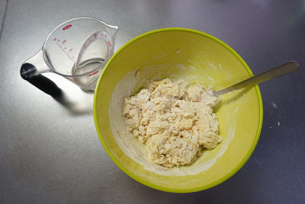 ドライイーストめがけて水を9割入れ、スプーンや菜箸で混ぜます。