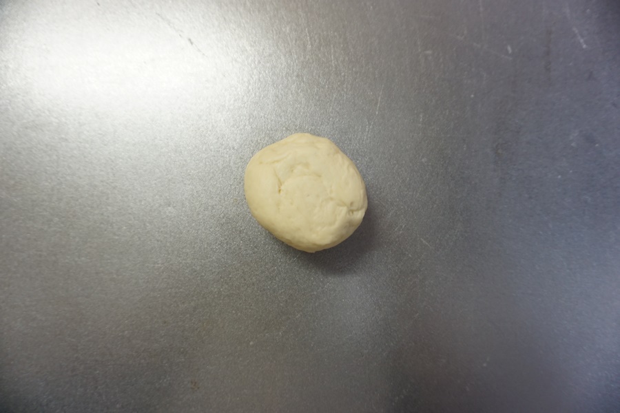 パン生地を捏ね台に出し、軽く空気を抜きます。