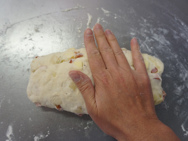 手前側の生地3分の1も向こう側に折りたたみます。重なった部分を軽くおさえます。