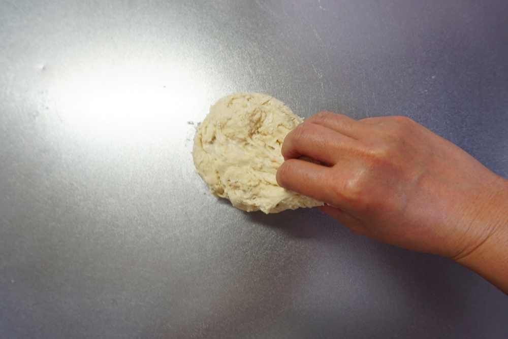 生地の端をつかんで、台に打ち付ける動作を3分繰り返します。