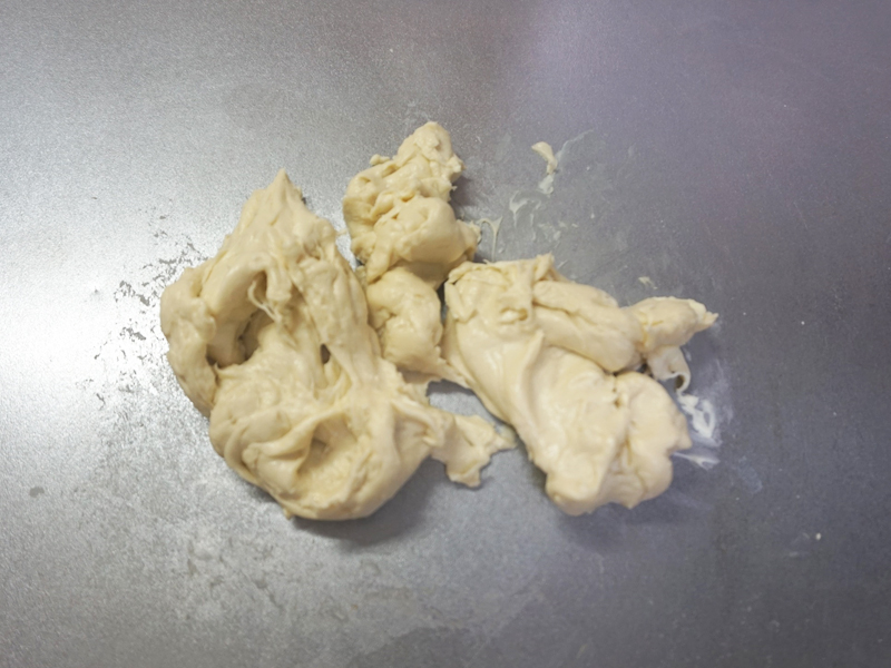 バターを入れてさらに捏ねます。 せっかくまとまった生地がバラバラになりますが、表面のテカリが消え、しっとりするまで約5分程度捏ねます。 
