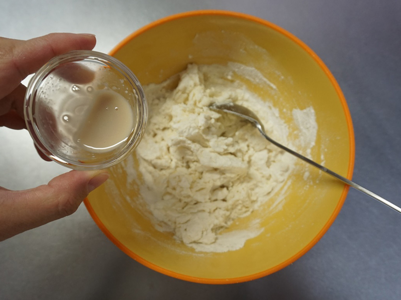 ボウルに溶いたドライイーストと、はちみつ入りの水を9割入れ、スプーンや菜箸で混ぜます。