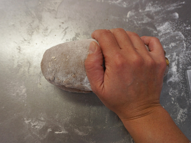 手前側の3分の1を向こう側に折り、とじ目を手で押さえます。