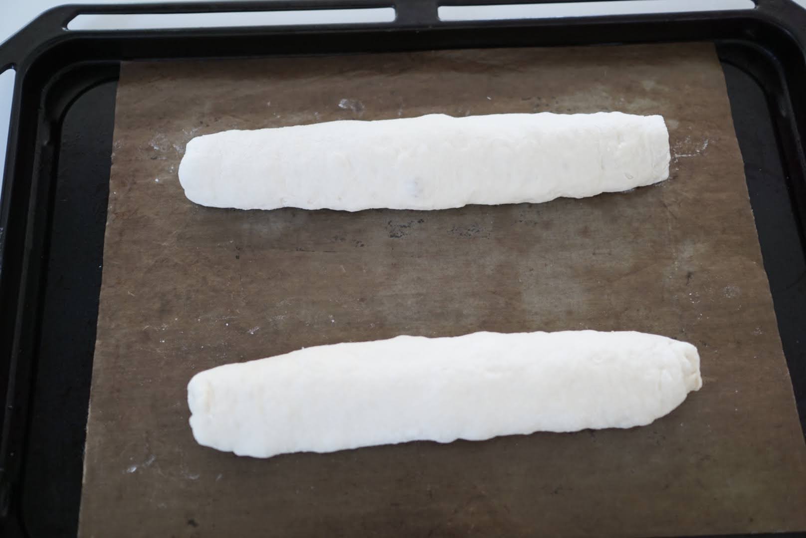 【二次発酵】 天板にオーブンシートを敷いて、閉じ目が下になるように生地を並べます。 キャンバス生地を使わなくても問題ありません。