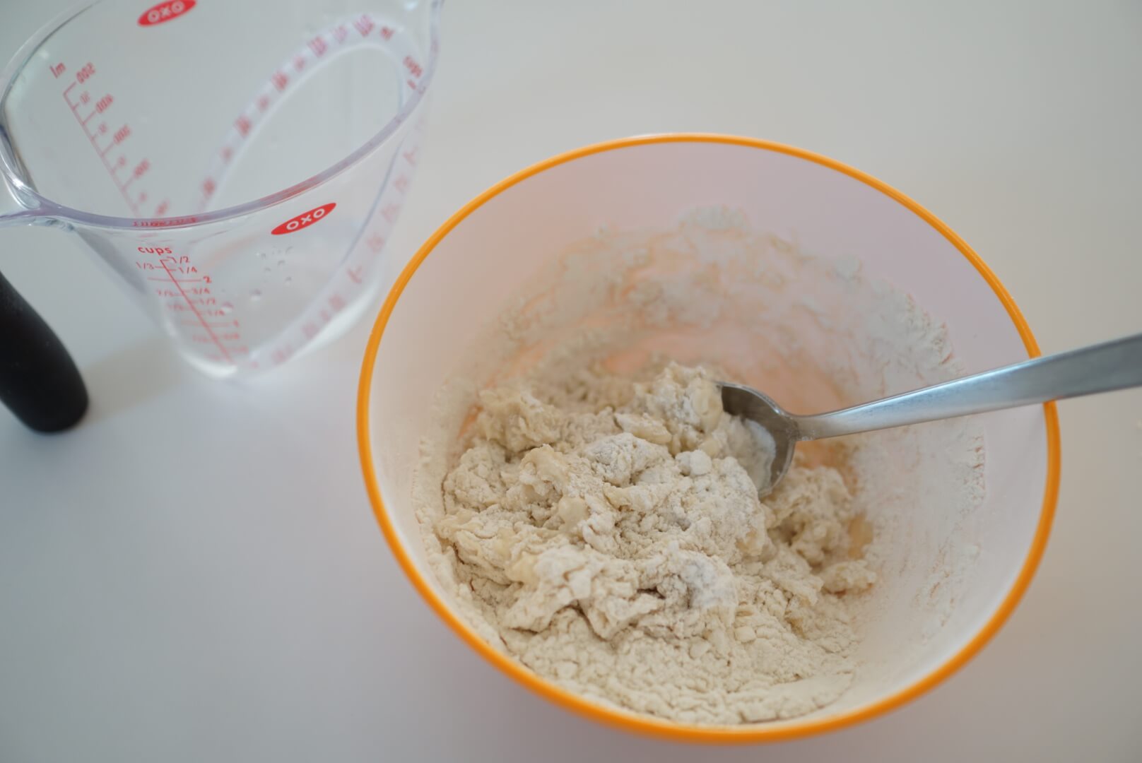 ボウルに牛乳を9割入れ、スプーンや菜箸で混ぜます。 生地の状態を見ながら牛乳を足し、さらに混ぜます。