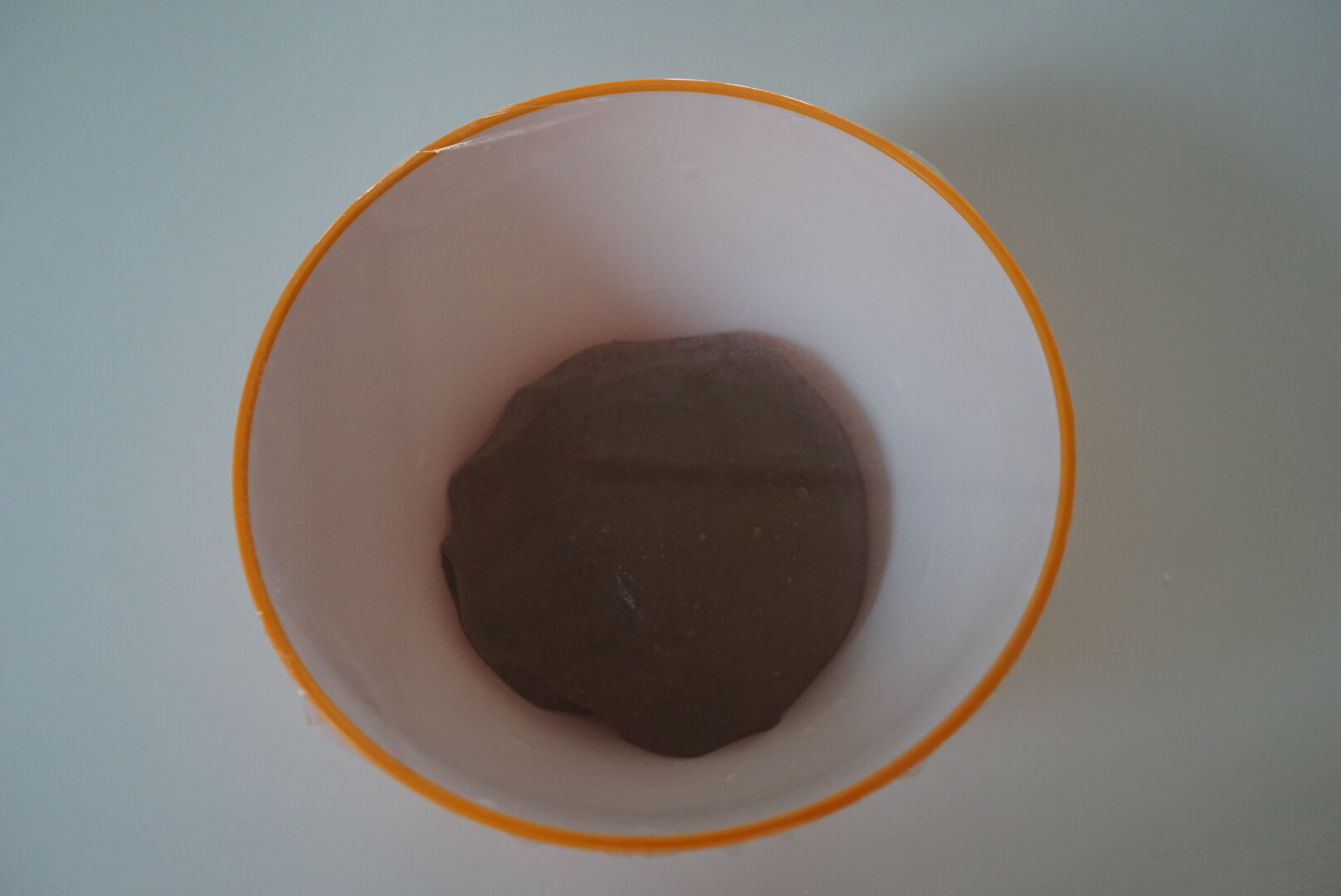 【一次発酵】 生地を丸めて閉じ目を下にして、ボウルに入れます。 ラップをかけ、暖かいところで50分程度発酵させます。