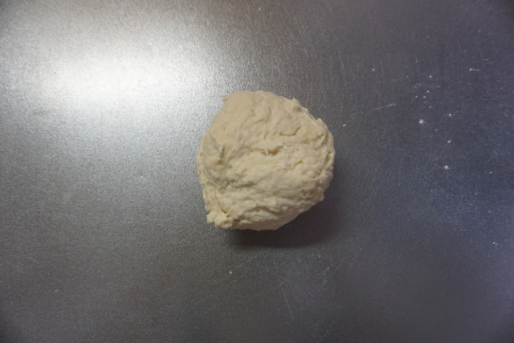 生地の状態を見ながらはちみつ入りの水を足し、さらに混ぜます。ボウルの中で生地がまとまったところで捏ね台に出し、3分捏ねます。