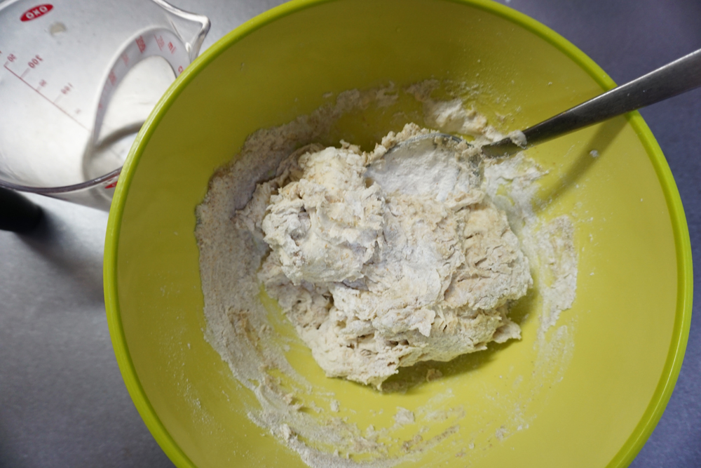 ボウルに溶いたドライイースト、水を9割入れ、スプーンや菜箸である程度混ぜ、塩を入れてさらに混ぜます。