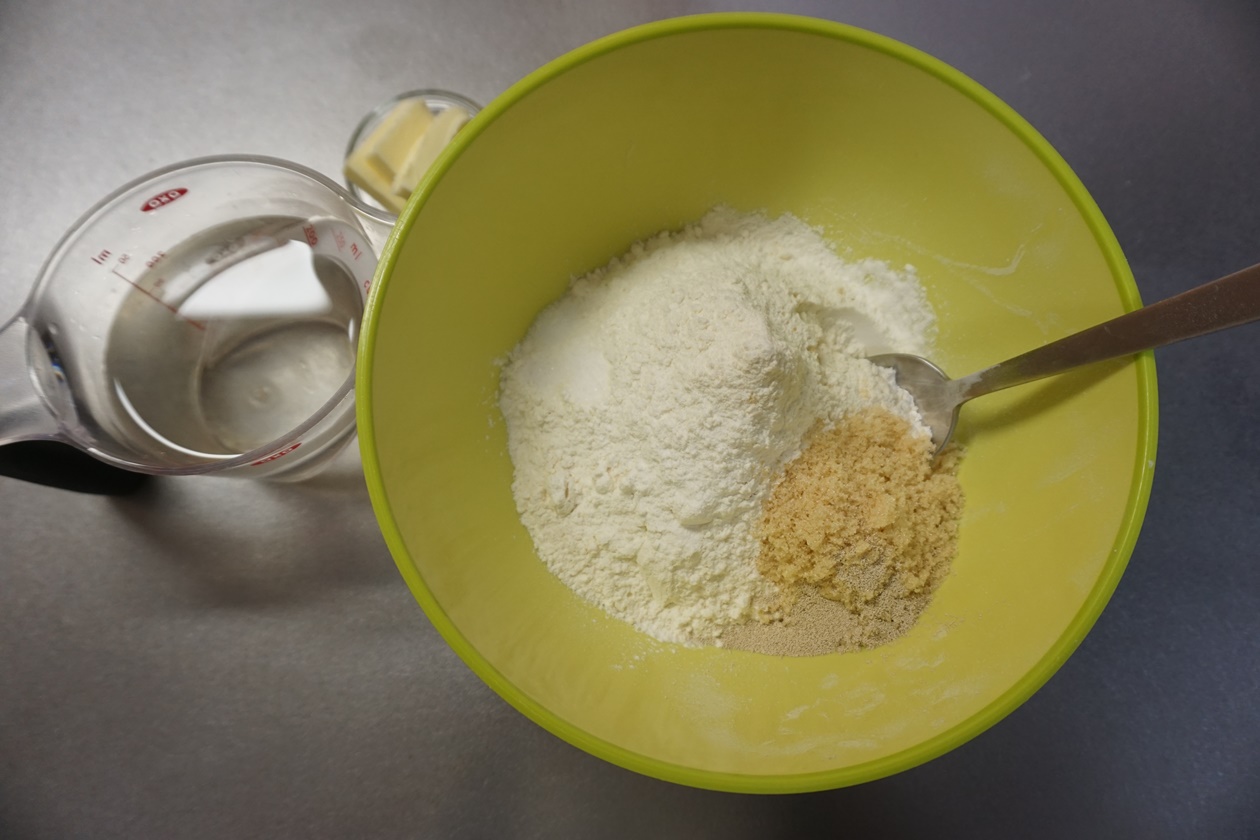 ボウルに強力粉・ドライイースト・砂糖を入れておきます。 バター、塩、ぬるま湯はそれぞれ別に用意しておきます。