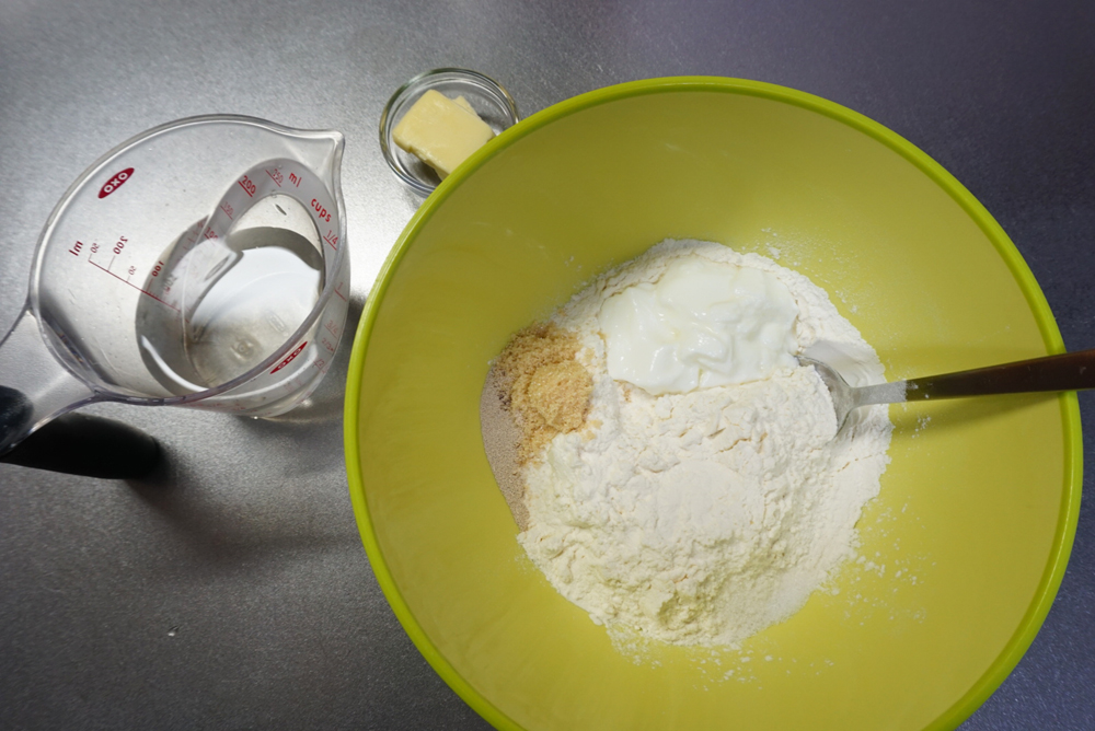 ボウルに強力粉を入れます。 ドライイーストと砂糖は隣り合わせで、ヨーグルトと塩は離してボウルに入れます。バター、ぬるま湯はそれぞれ別に用意しておきます。