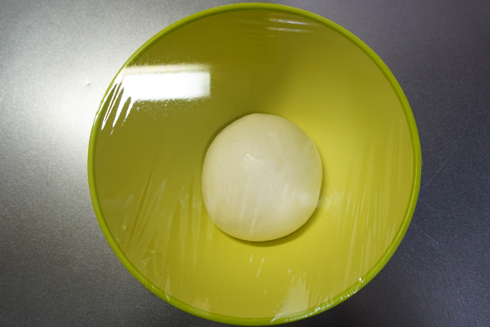 一次発酵:ラップをかけて、暖かい場所で約1時間発酵させます。夏場は常温、冬場はオーブンの発酵機能(35℃)を使うと便利です。時間はあくまでも目安です。生地が2倍になるまで待ってください。