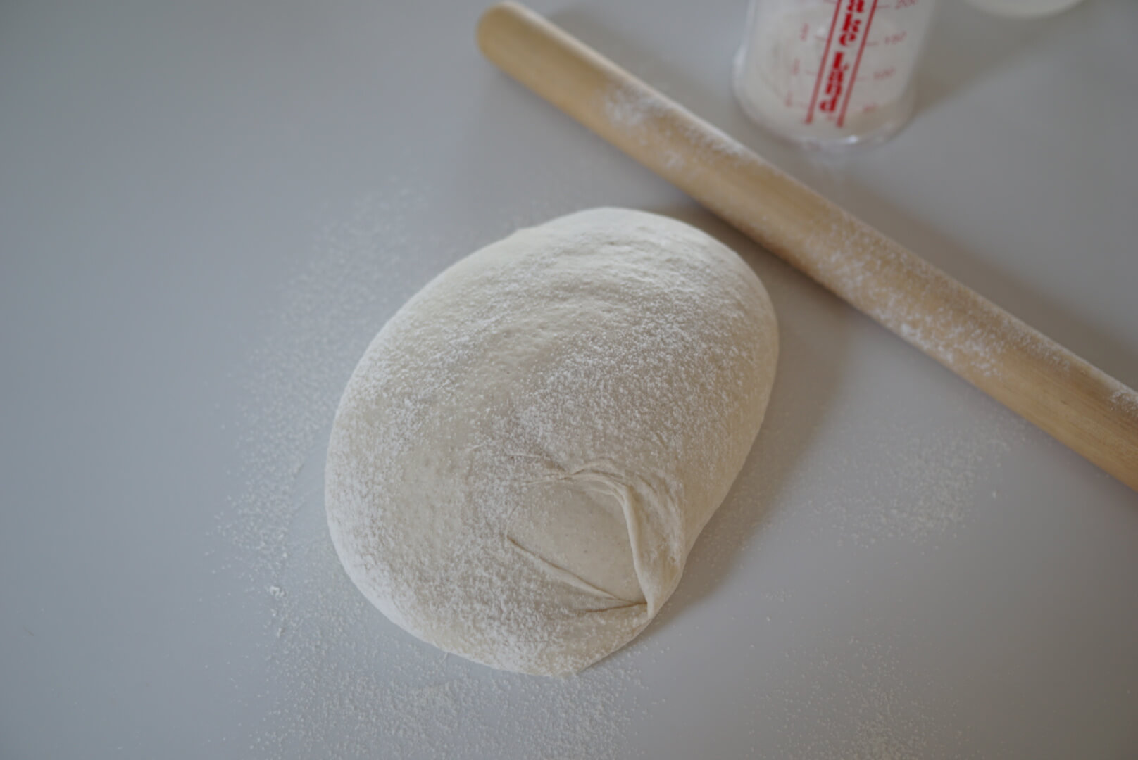 1.5倍から2倍に膨らんだところで発酵完了です。 打ち粉の強力粉（分量外）を振って、台に生地を出します。